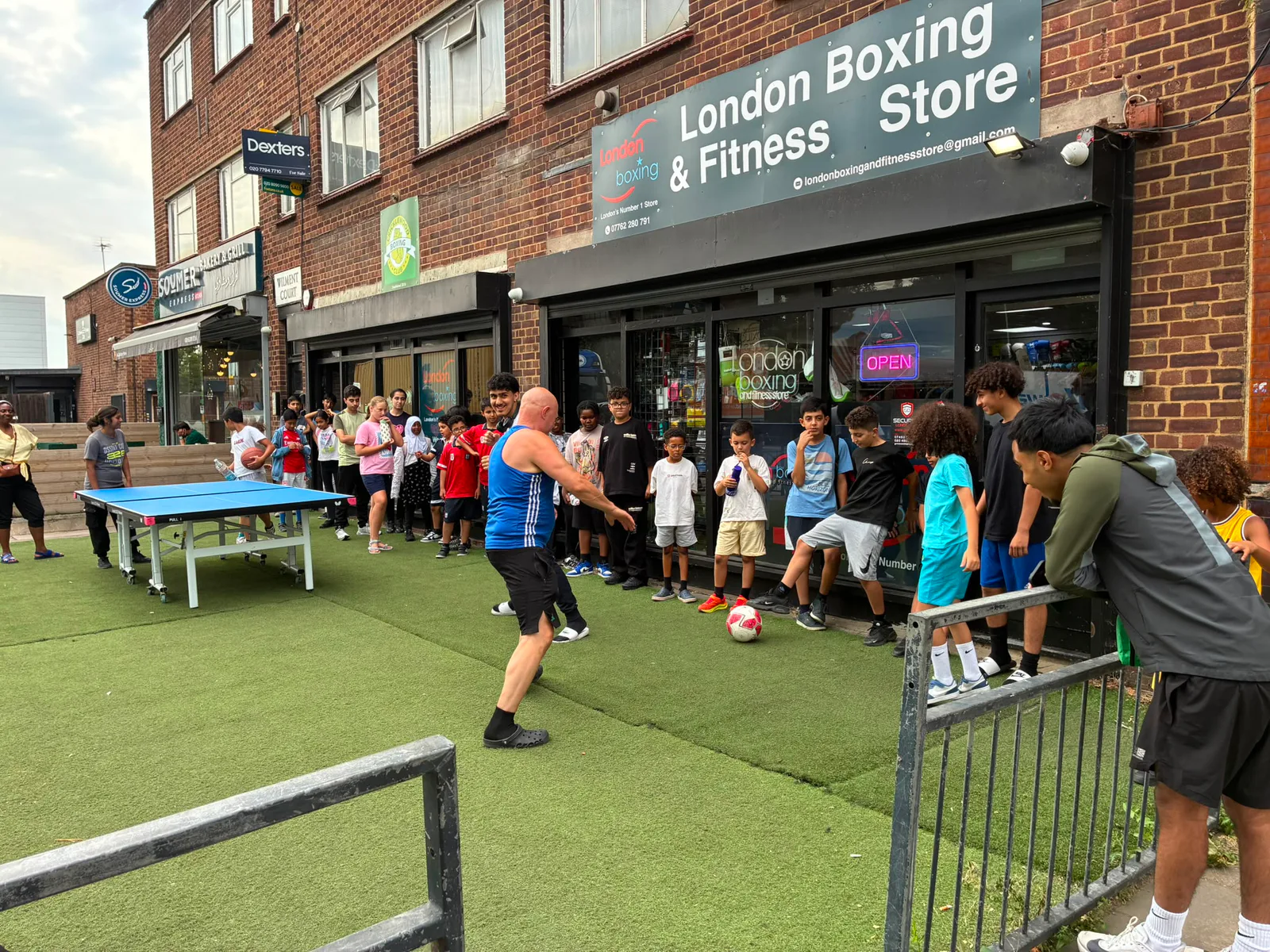 Young people gathered outside London Boxing and Fitness Store during a community open day